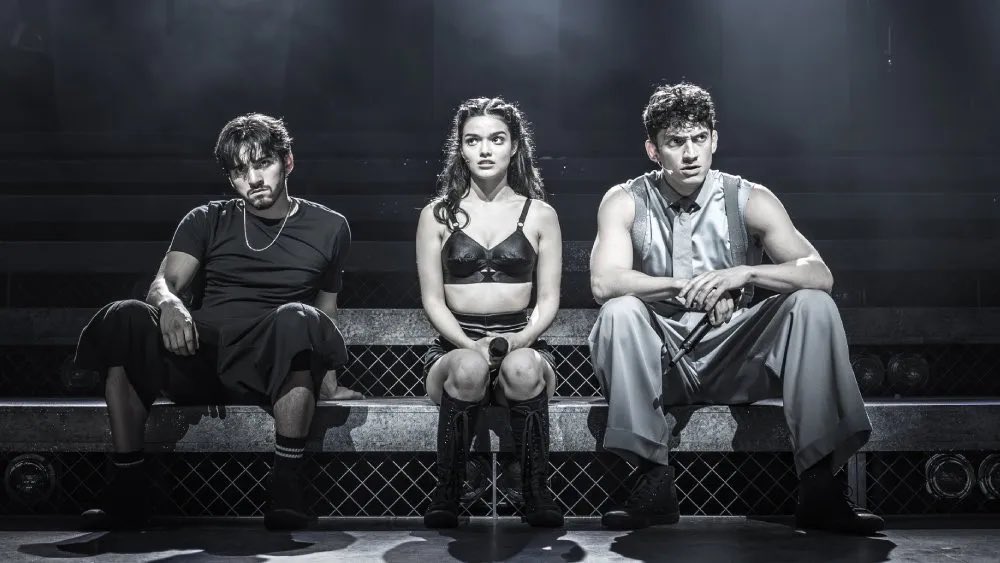 The Evita cast seated onstage