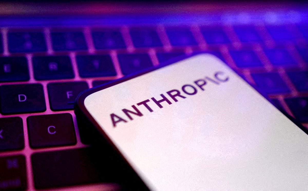 The Anthropic name displayed on a phone beside a computer keyboard.