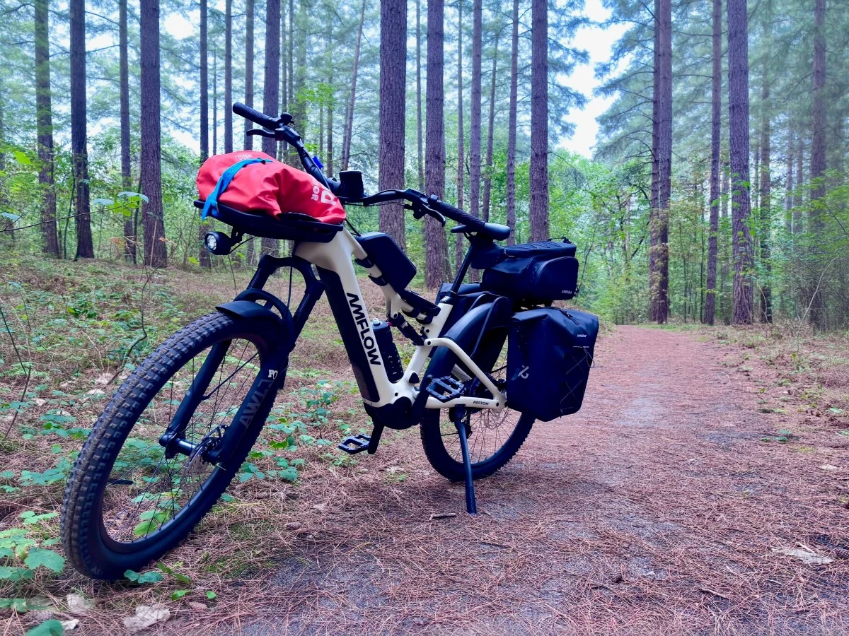 The Amflow TL Carbon e-bike configured with racks and bags for mixed city and trail riding.