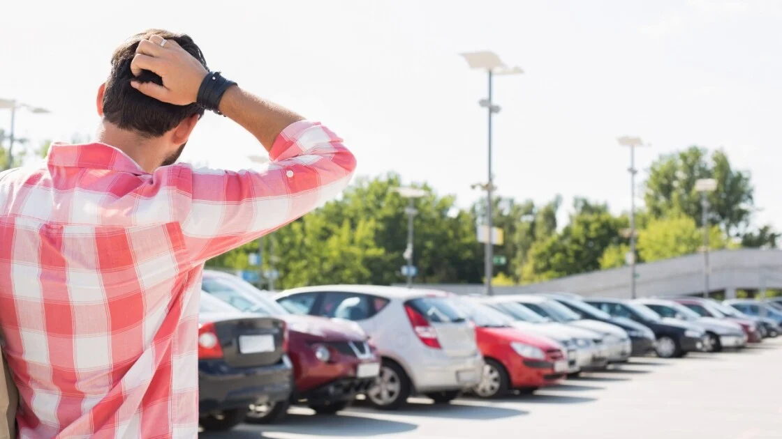 A smartphone displays a map beside a parked car.