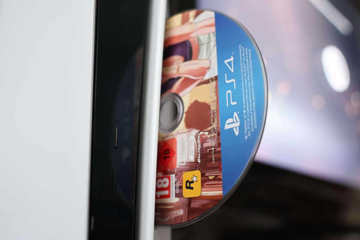 PlayStation 5 console and controller beside physical game cases.
