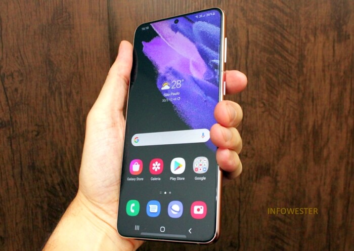 A Samsung Galaxy smartphone held in one hand with its Android home screen visible.