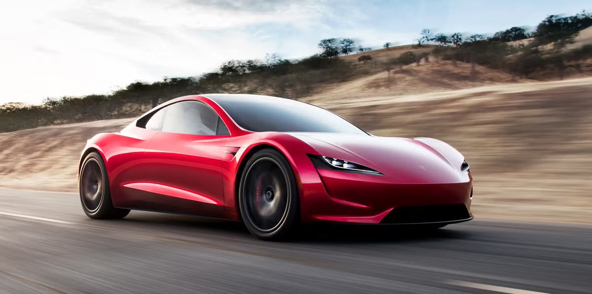 A red Tesla Roadster design is shown from the front three-quarter angle.