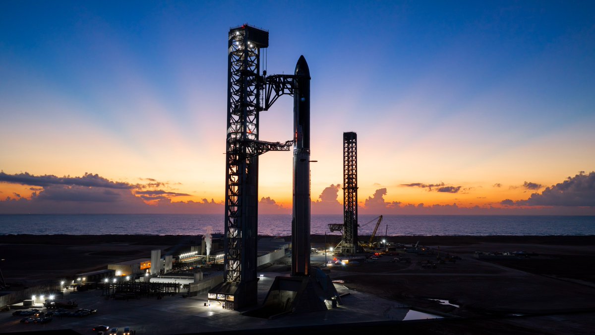 Starship and Super Heavy stacked at SpaceX’s Starbase launch site at sunrise.