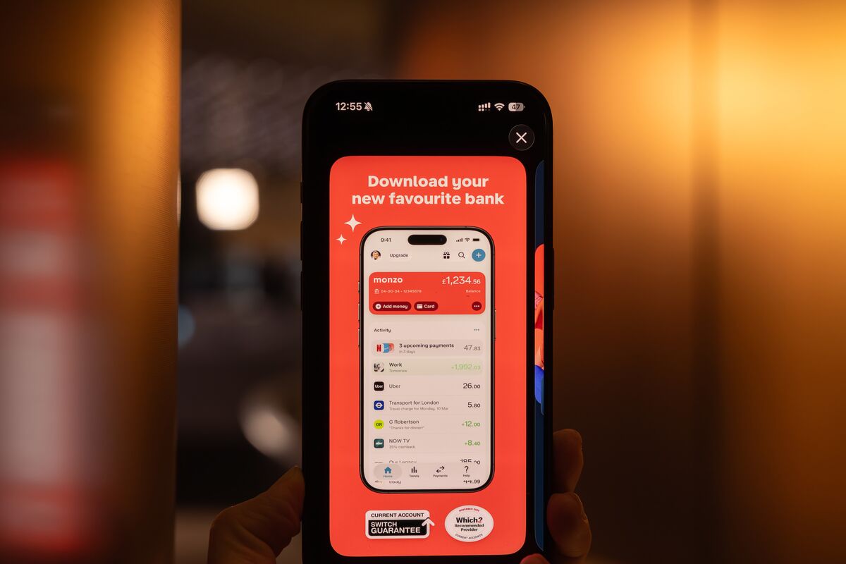 A phone displaying the Monzo banking app and a Monzo advertisement.