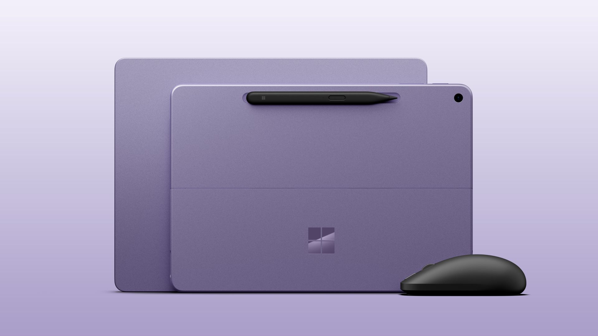 Two purple Microsoft Surface devices shown from the back with a Surface Slim Pen and black Surface Mouse.