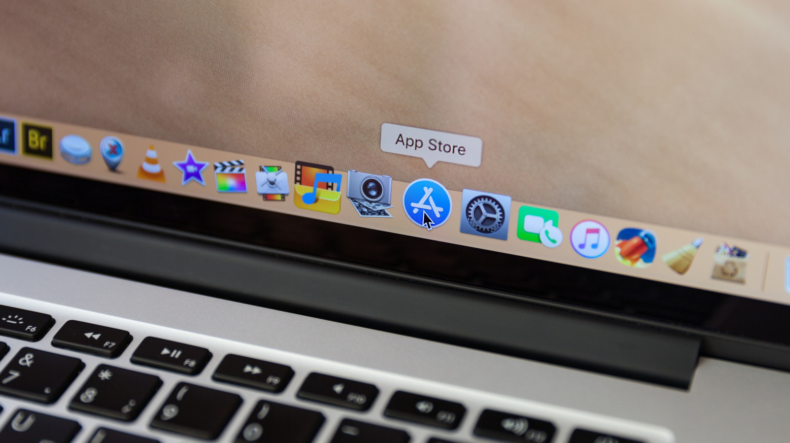 Close-up of an older MacBook screen and keyboard with the macOS Dock visible.